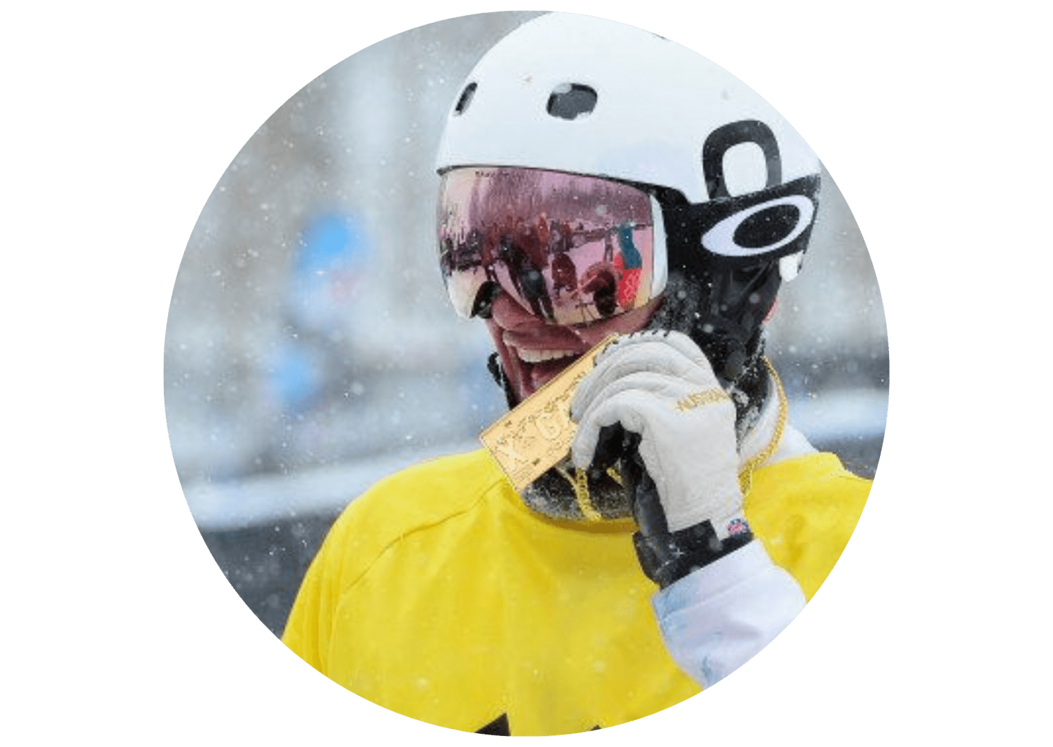 A person in yellow jacket holding up a medal.