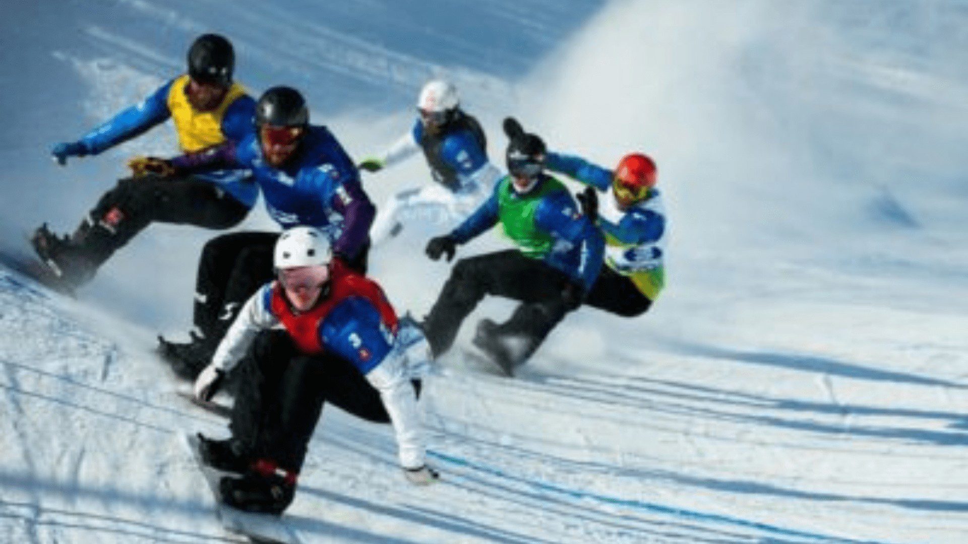 Snowboarders race down snowy slope.